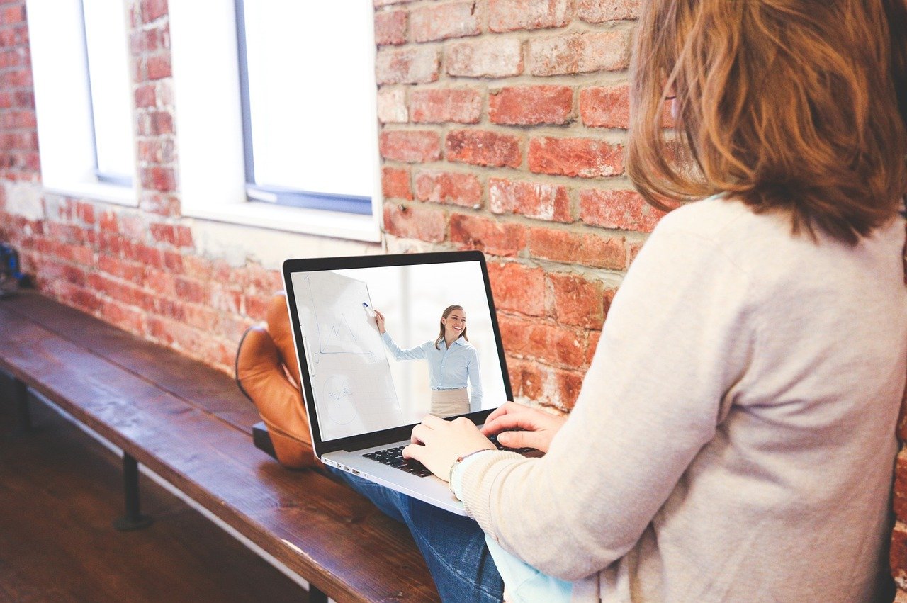 Mujer siguiendo una clase online en su portátil, en la Academia Cómplices