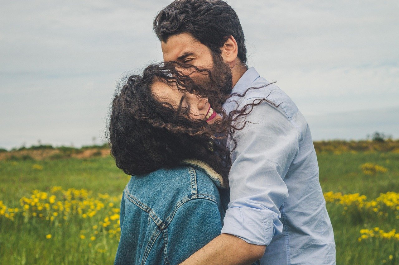 Pareja abrazada y sonriente al aire libre, tras reconectar en terapia de pareja